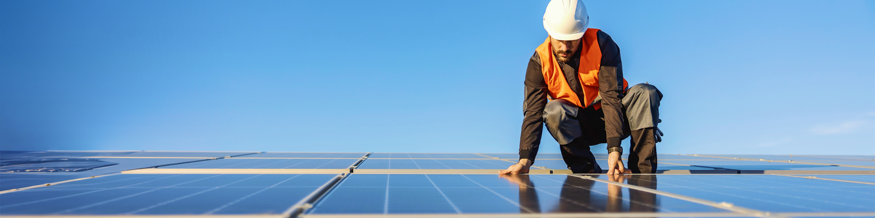 Hombre con casco en paneles solares Hombre con casco en paneles solares