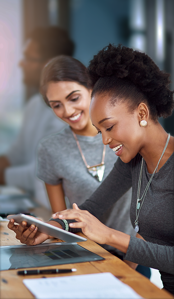 Dos mujeres sonriendo y mirando un iPad Dos mujeres sonriendo y mirando un iPad