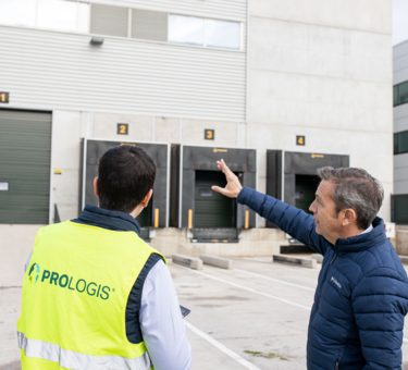 two members in front a warehouse